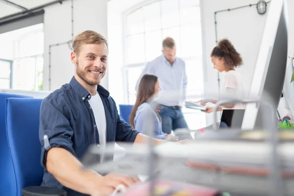 Ung Programmerare Sitter Vid Skrivbord Och Leende — Stockfoto