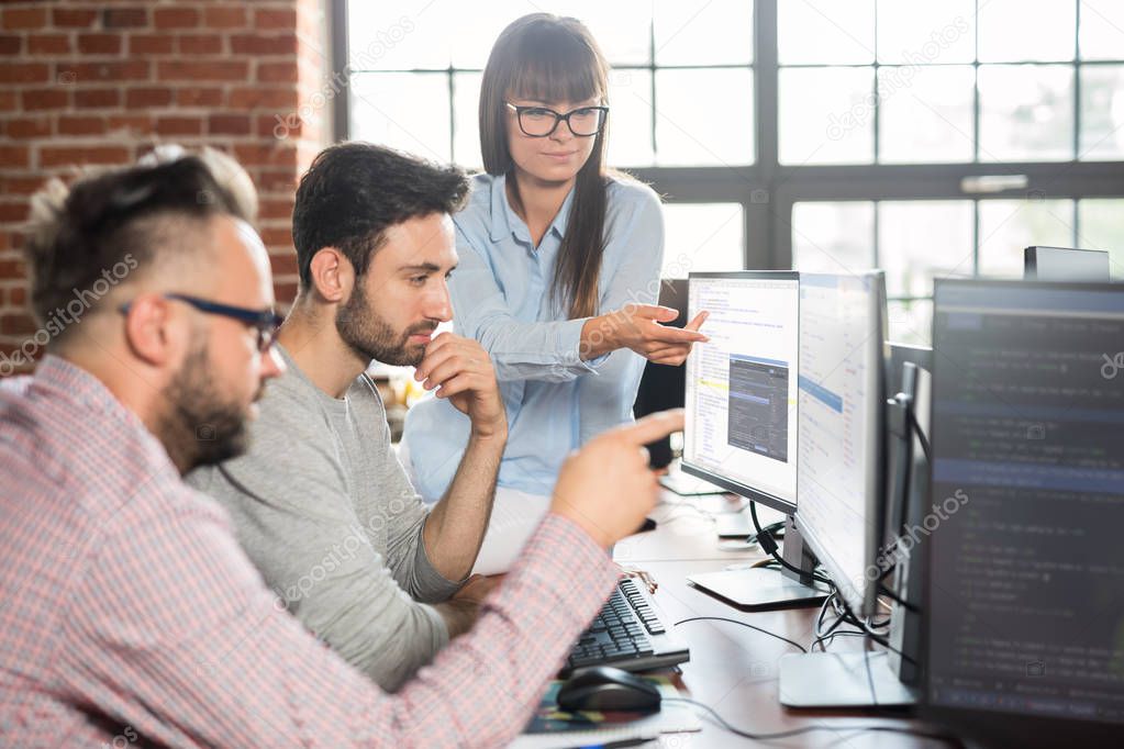 Programmers team interacting by computer screens in office