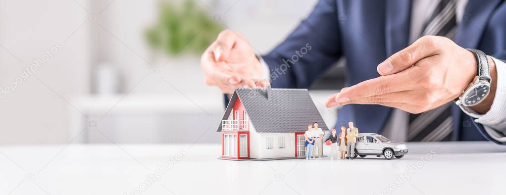  insurance agent with house, car and family toys