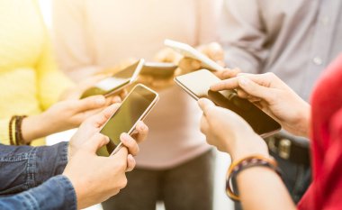 Bir grup genç insan akıllı telefonlar elinde tutan