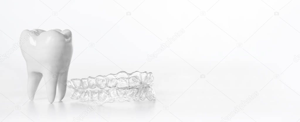 Inivisalign braces with tooth model on whiite background