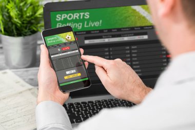 app ve site spor bahisleri ile Smartphone ve dizüstü bilgisayar kullanan adam