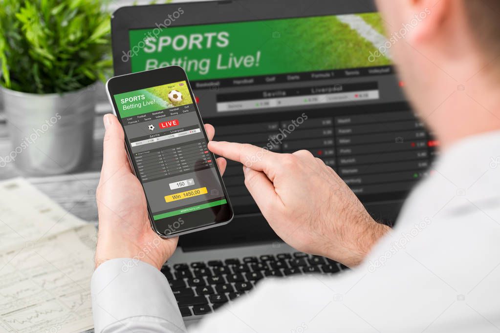 man using smartphone and laptop with sports betting app and site