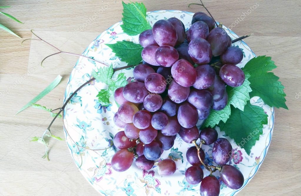 bunch of grapes lie on a white plate