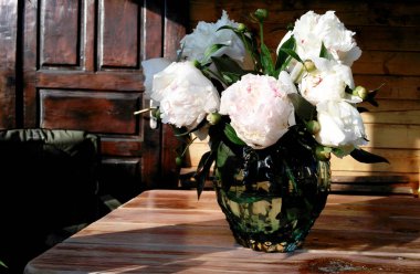 bir tabloda bir turkuaz cam vazoda beyaz peonies