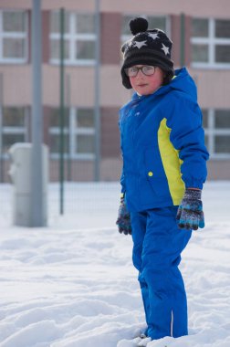 Kış sırasında oynarken bir küçük aucasian çocuk