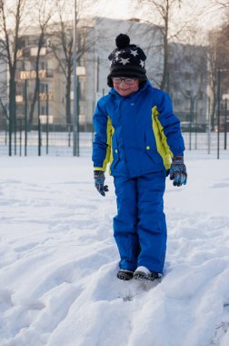 Kış sırasında oynarken bir küçük aucasian çocuk