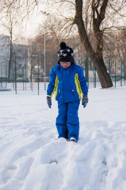 Kış sırasında oynarken bir küçük aucasian çocuk