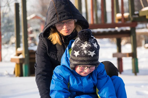 Kış sırasında zledge ile oynayan küçük bir çocuk