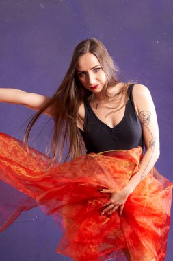 Turuncu kuşakla dans eden hoş ve formda bir kız..                                        