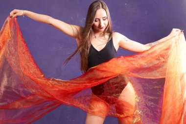 Turuncu kuşakla dans eden hoş ve formda bir kız..                                        