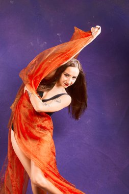 Turuncu kuşakla dans eden hoş ve formda bir kız..                                        