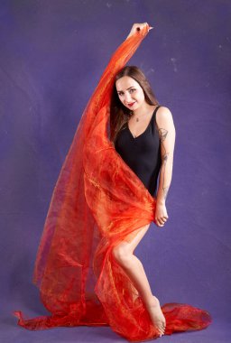 Turuncu kuşakla dans eden hoş ve formda bir kız..                                        