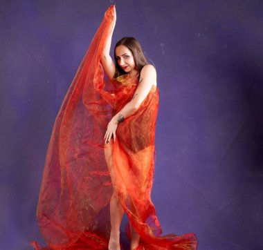 Turuncu kuşakla dans eden hoş ve formda bir kız..                                        