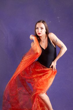 Turuncu kuşakla dans eden hoş ve formda bir kız..                                        