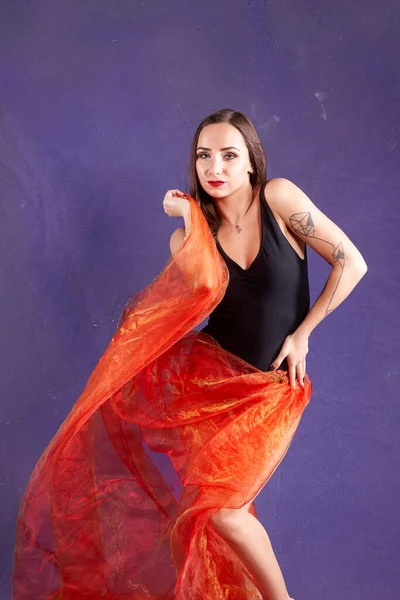 Turuncu kuşakla dans eden hoş ve formda bir kız..                                        