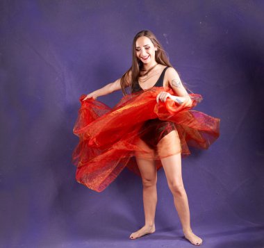 Turuncu kuşakla dans eden hoş ve formda bir kız..                                        