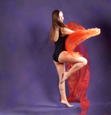 Turuncu kuşakla dans eden hoş ve formda bir kız..                                        