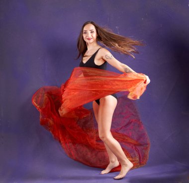 Turuncu kuşakla dans eden hoş ve formda bir kız..                                        