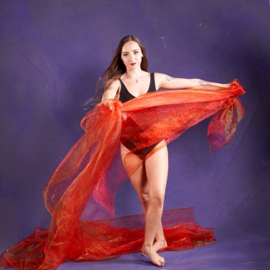 Turuncu kuşakla dans eden hoş ve formda bir kız..                                        