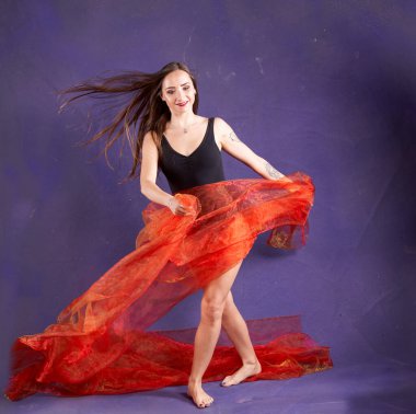 Turuncu kuşakla dans eden hoş ve formda bir kız..                                        