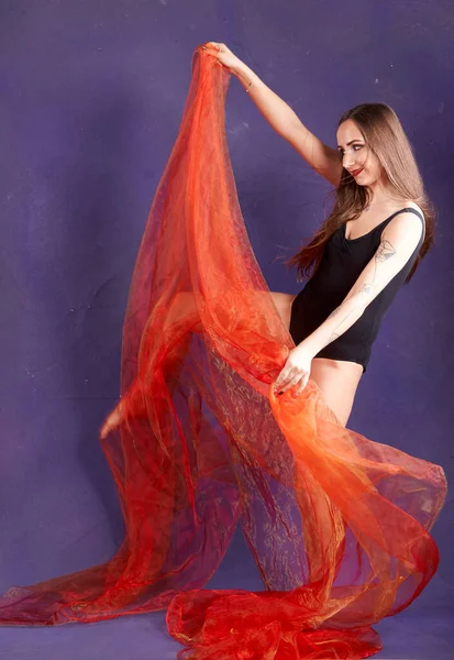 Turuncu kuşakla dans eden hoş ve formda bir kız..                                        