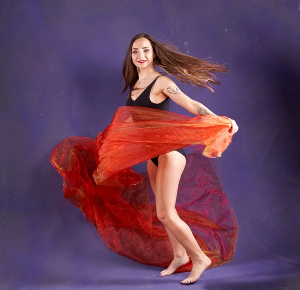 Turuncu kuşakla dans eden hoş ve formda bir kız..                                        