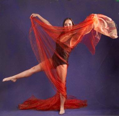 Turuncu kuşakla dans eden hoş ve formda bir kız..                                        