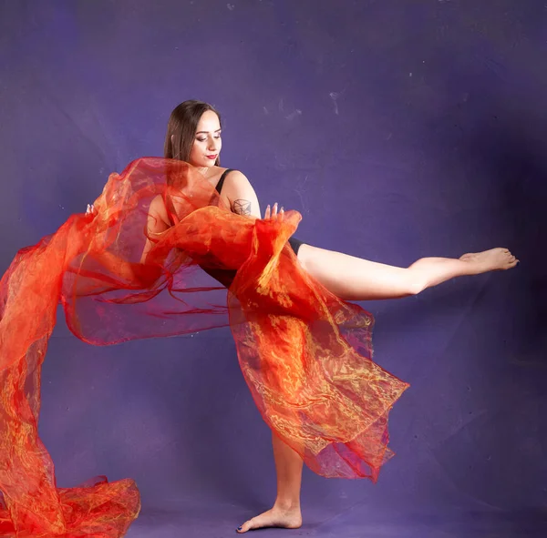 Turuncu kuşakla dans eden hoş ve formda bir kız..                                        