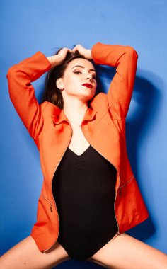  Siyah vücut ve turuncu ceket giyen, mavi arka planda, zıt görüşlü genç bir kız.          