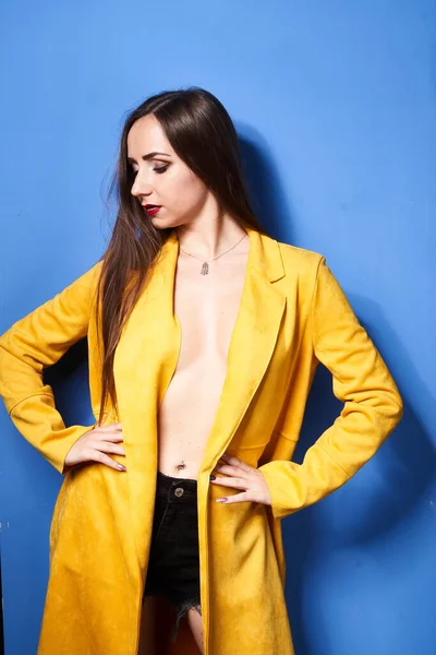 Uma Bela Menina Posa Casaco Amarelo Contra Uma Parede Azul — Fotografia de Stock