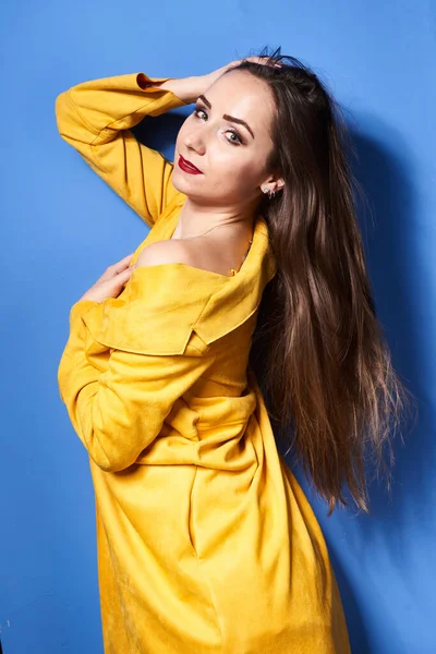 Uma Bela Menina Posa Casaco Amarelo Contra Uma Parede Azul — Fotografia de Stock