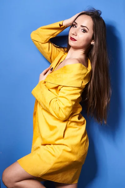 Uma Bela Menina Posa Casaco Amarelo Contra Uma Parede Azul — Fotografia de Stock