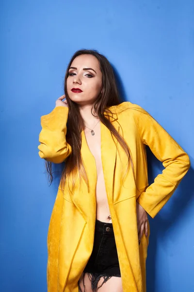 Uma Bela Menina Posa Casaco Amarelo Contra Uma Parede Azul — Fotografia de Stock