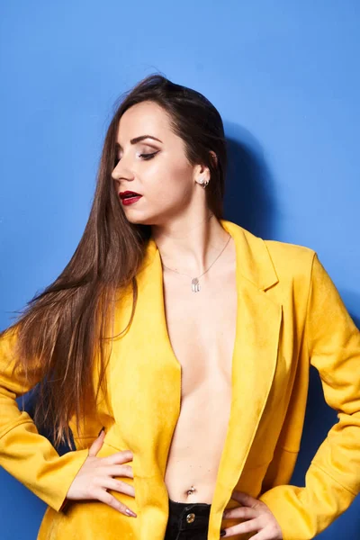 Uma Bela Menina Posa Casaco Amarelo Contra Uma Parede Azul — Fotografia de Stock