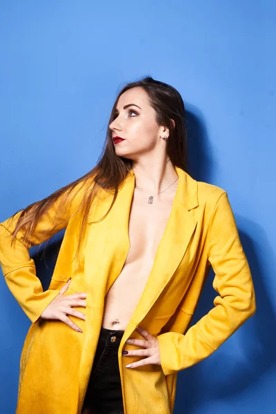 Una Hermosa Chica Posa Abrigo Amarillo Contra Una Pared Azul —  Fotos de Stock