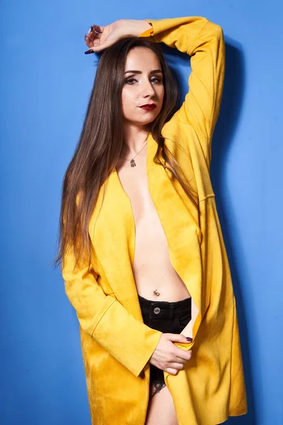 Beautiful Girl Poses Yellow Coat Blue Wall — Stock Photo, Image