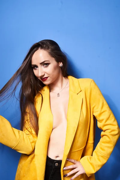 Uma Bela Menina Posa Casaco Amarelo Contra Uma Parede Azul — Fotografia de Stock