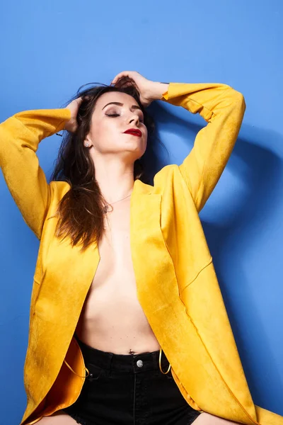 Ein Schönes Mädchen Posiert Einem Gelben Mantel Vor Einer Blauen — Stockfoto