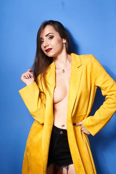 Una Hermosa Chica Posa Abrigo Amarillo Contra Una Pared Azul — Foto de Stock