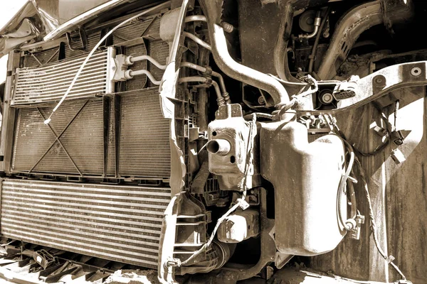 Old broken and dirty car engine close up, view under the hood in sepia tones