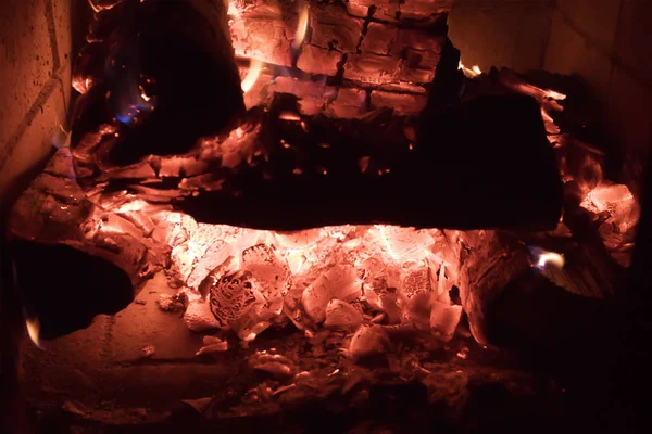 Hot coals burning out in the fireplace closeup, glamorous natural background