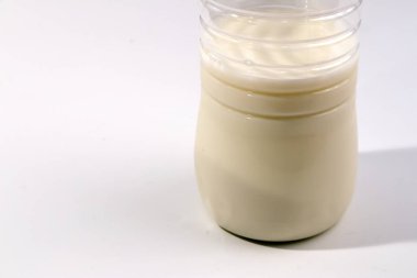 Alt kısmındaki saydam plastik şişe süt beyaz izole yarısı dolu