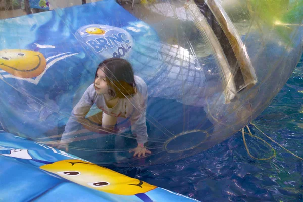スイミングプールで大きな透明な水泡の中で遊ぶ小さな女の子 — ストック写真