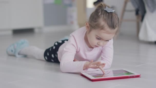 Entspannendes Mädchen spielt Tablet auf dem Boden — Stockvideo