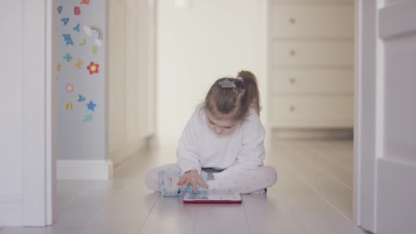 Dziewczyna bawi tabletka na piętrze w domu — Wideo stockowe