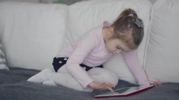 Випадкова дівчина використовує планшет на дивані — стокове відео