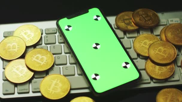 Smartphone en bitcoins op toetsenbord — Stockvideo