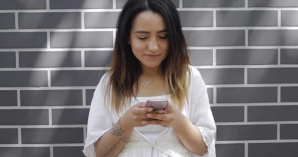 Молода жінка читає повідомлення на мобільному телефоні — стокове відео