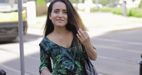 Молодая женщина стоит перед уличным трамваем — стоковое видео